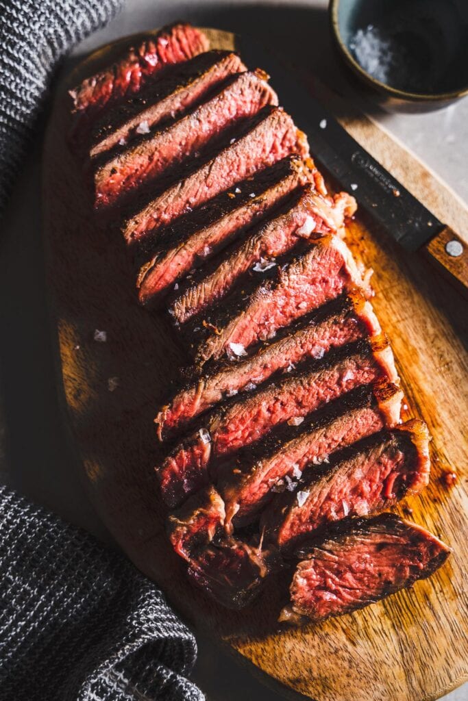 New York Strip Steak sliced on cutting board