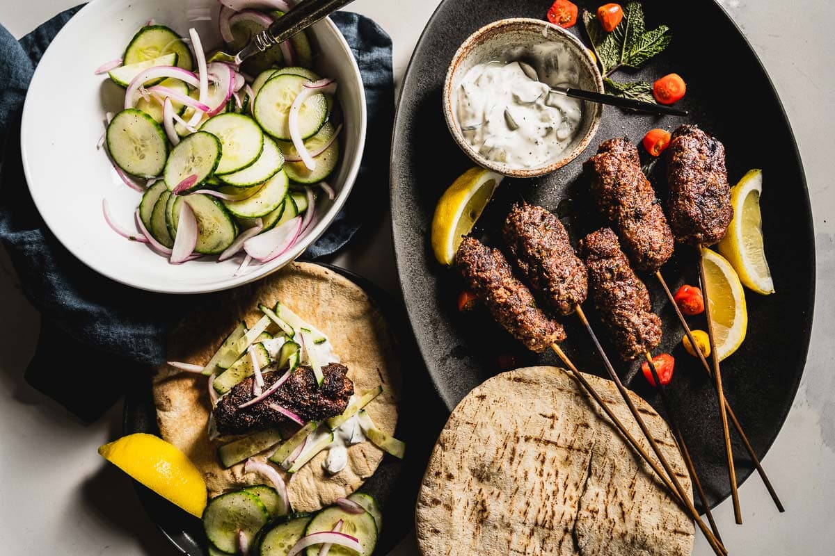 adana kebabs with cucumber salad overhead