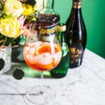 aperol spritz cocktail on white marble with bottles