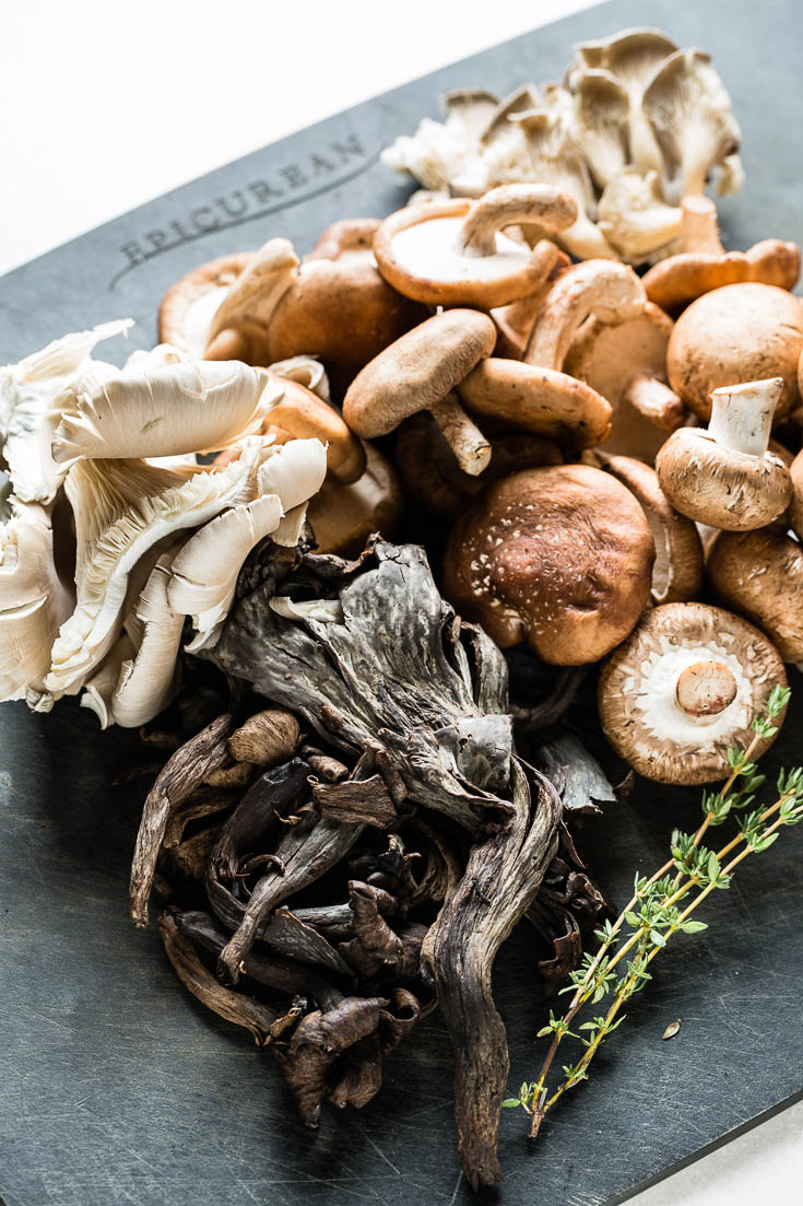 assorted wild mushrooms on cutting board