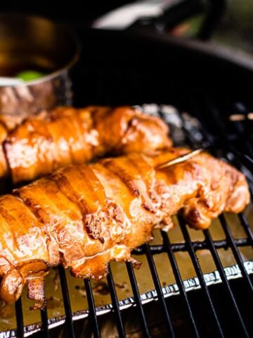 bacon wrapped pork tenderloin in smoker with glaze horizontal