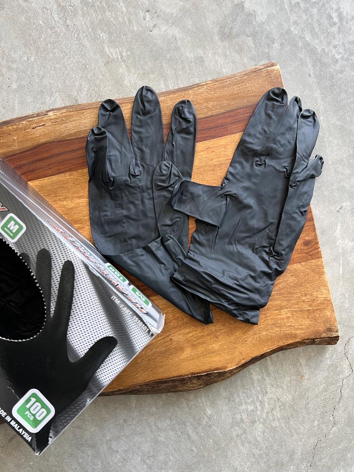 black nitrile gloves next to box on cutting board