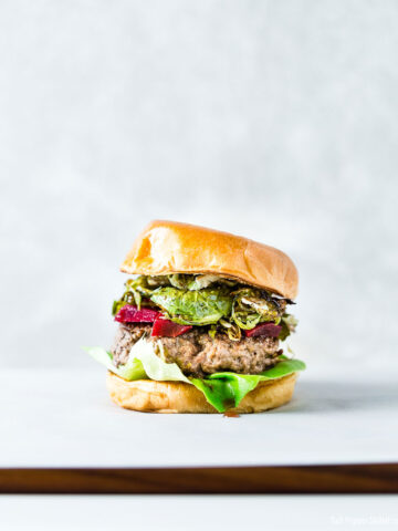 Brussels Sprouts and pickled beets burger on a brioche bun vertical