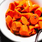 buttery boiled carrots in bowl vertical