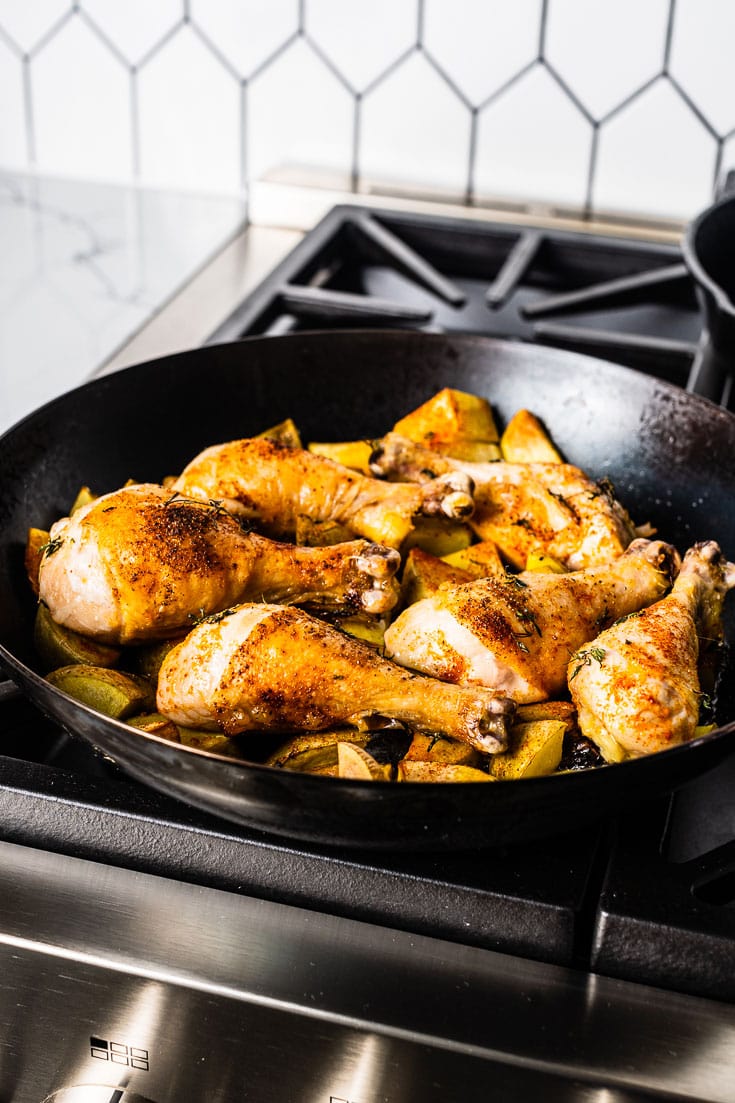 chicken drumsticks with potatoes in skillet
