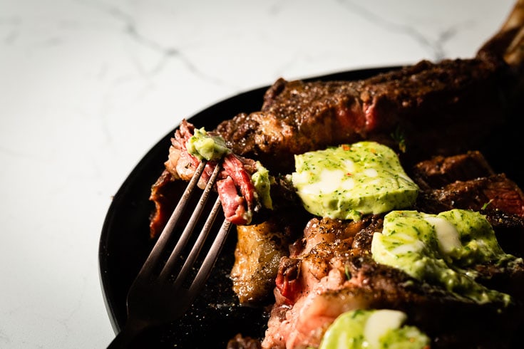 close up of sous vide tomahawk steak on fork