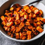 crispy roasted sweet potatoes in bowl vertical
