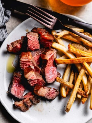 sous vide picanha steak sliced on plate with fries