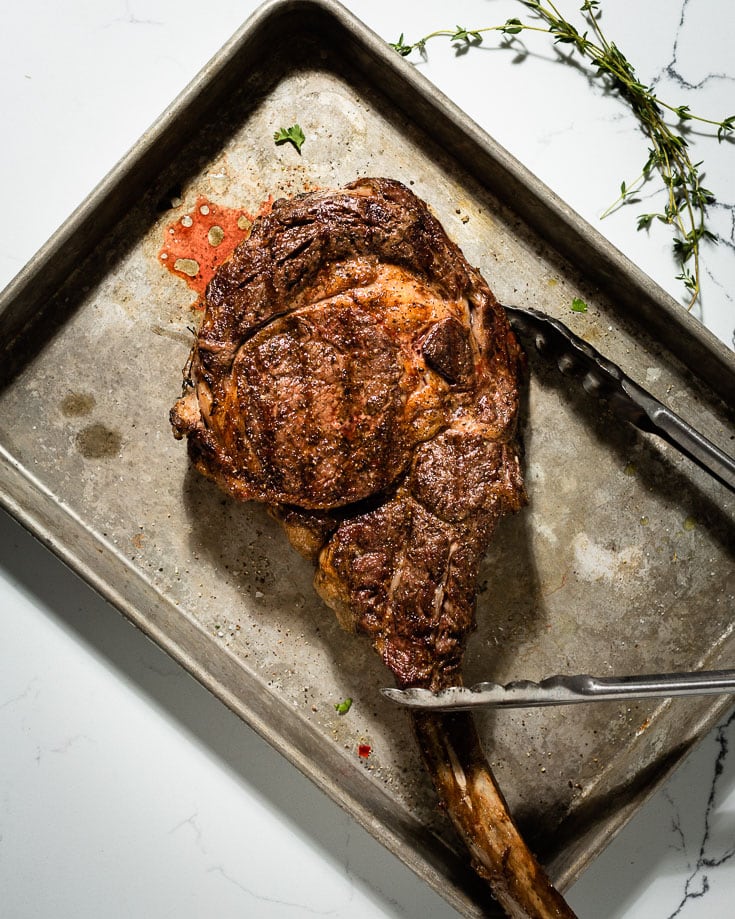 grill seared tomahawk steak on sheetpan