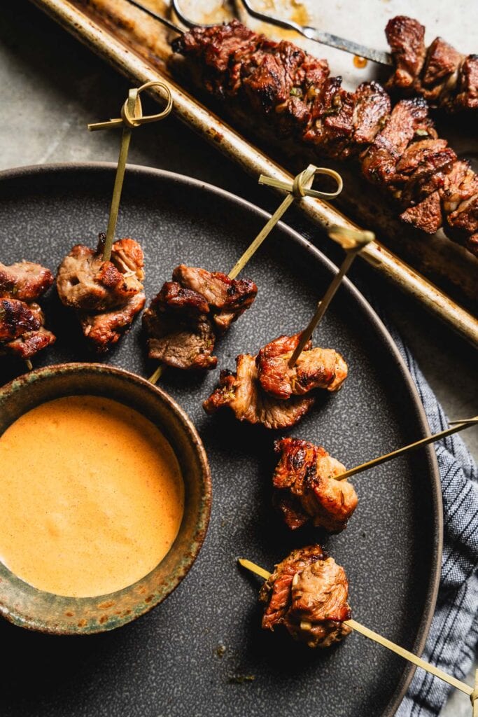 grilled lamb skewers on a plate with creamy chipotle dipping sauce