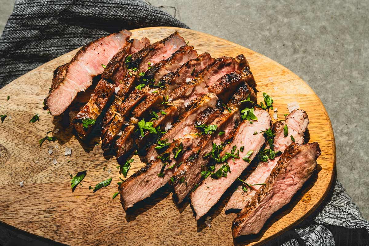 grilled pork steaks sliced on a cutting board