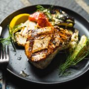grilled swordfish on plate with lemon and fennel