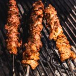 grilling lamb skewers on a charcoal grill