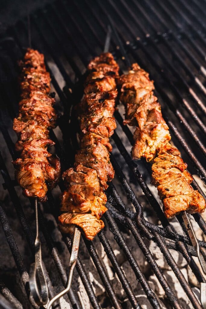 grilling lamb skewers on a charcoal grill