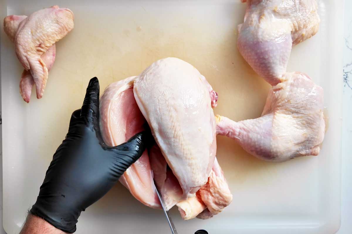 Cutting up a whole chicken on a cutting board