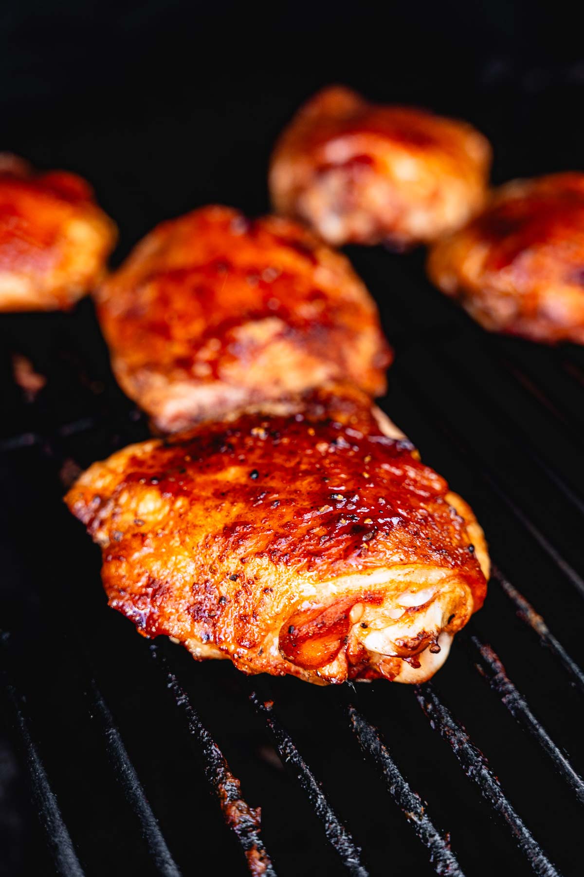 juicy smoked chicken thighs in smoker vertical