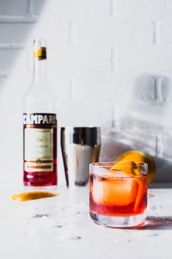 negroni cocktail recipe vertical side with campari bottle