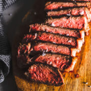 new york strip steak sliced on cutting board featured horizontal
