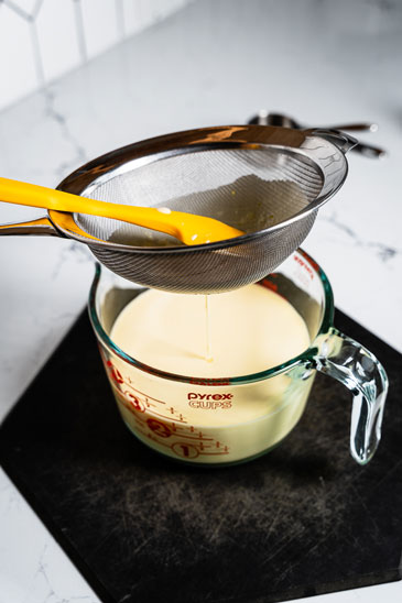 passing custard through strainer