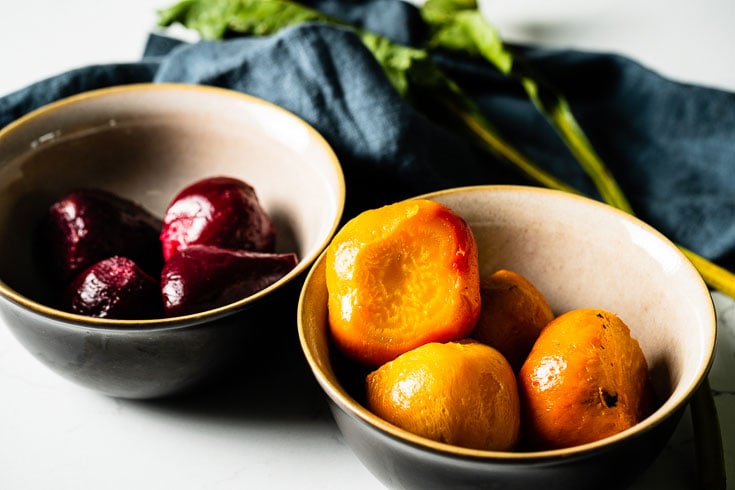 peeled and sliced roasted beets in bowls close up