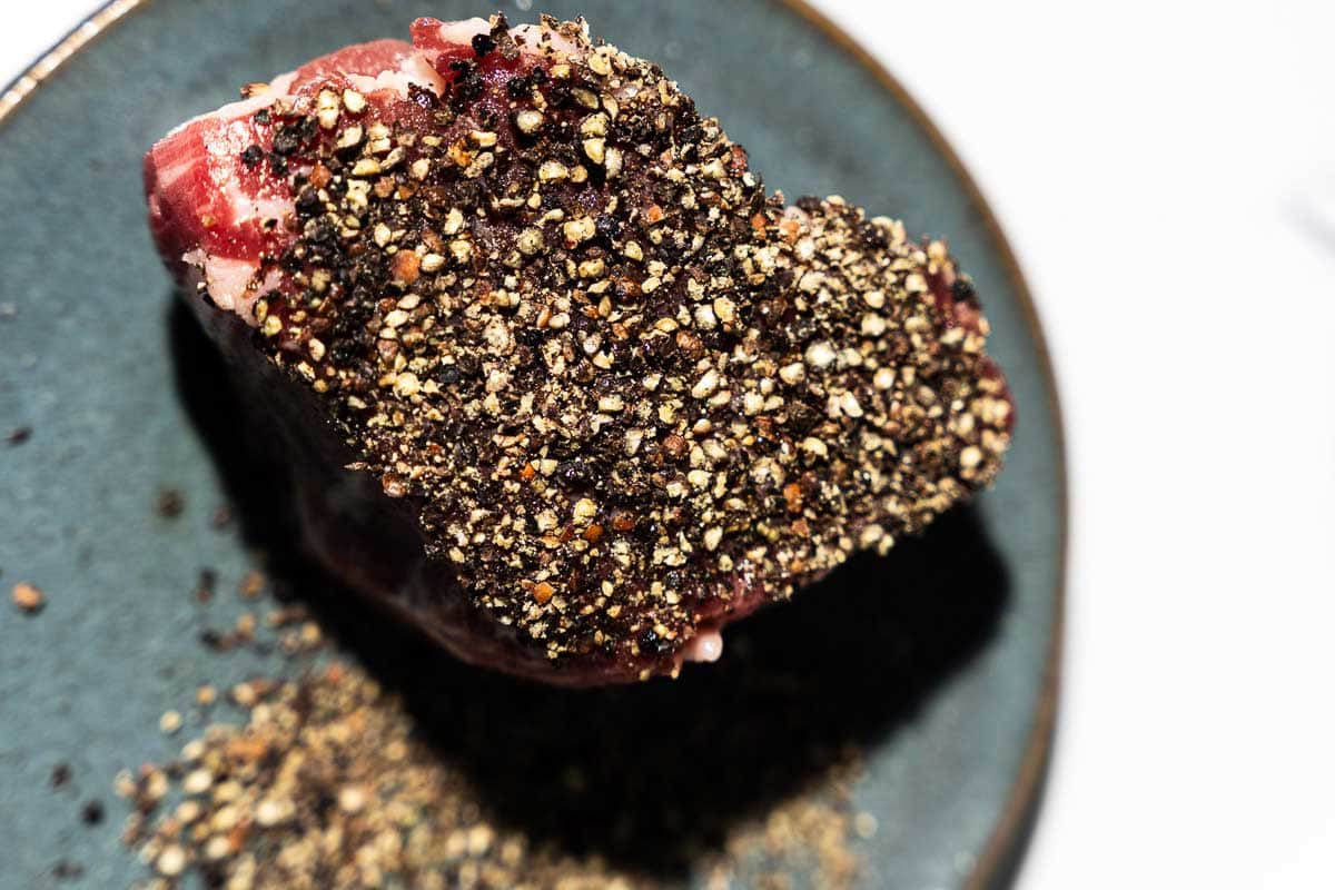 peppercorns crusted on steak before cooking