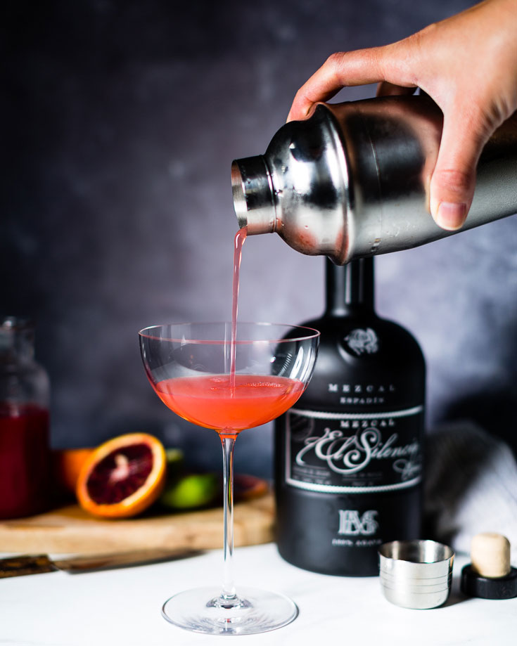 pouring mezcal blood orange gimlet