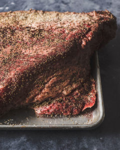 prime grade brisket point seasoned on a sheet pan.