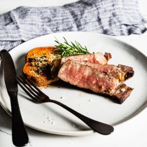 reverse seared steak with roasted sweet potato on plate