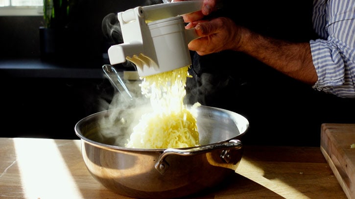 passing mashed potatoes through a ricer