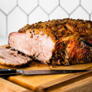 roast pork shoulder sliced on cutting board vertical