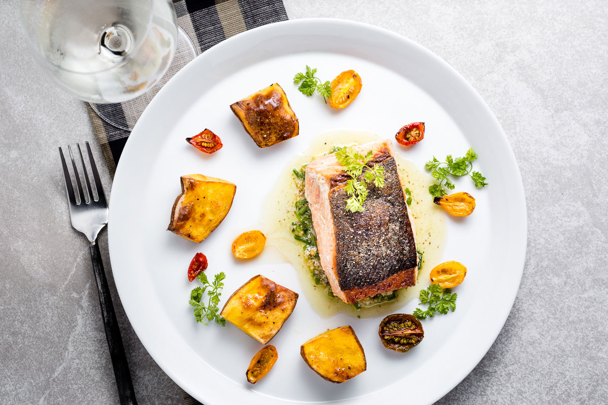 seared salmon with chive-walnut pistou, fingerling potatoes and half-dried tomatoes horizontal with wine