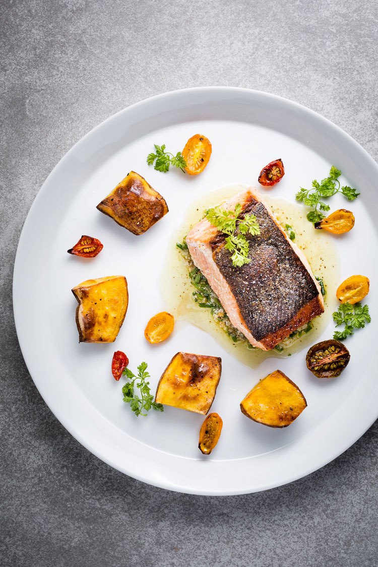 seared salmon with chive-walnut pistou, fingerling potatoes and half-dried tomatoes overhead vertical