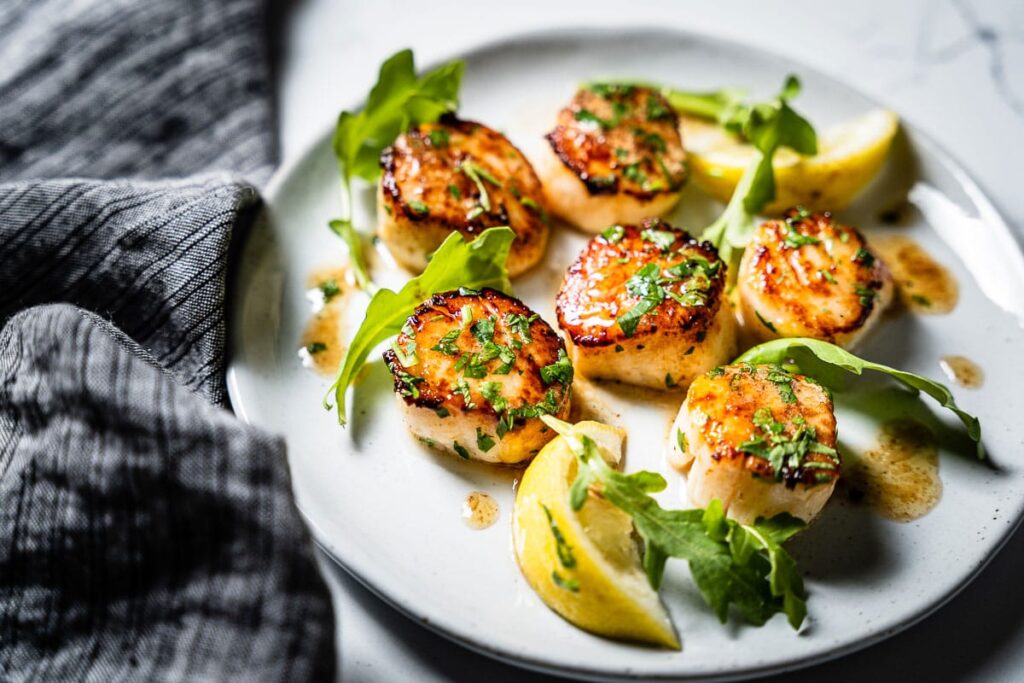 Seared Scallops On Plate With Arugula Side View 2 1024x683 