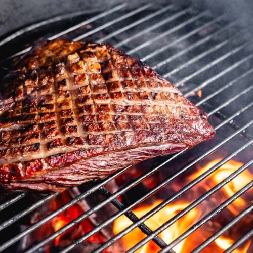 searing picanha steak in charcoal grill