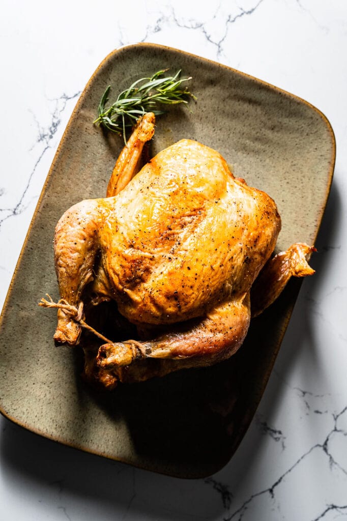 simple roast chicken on serving platter vertical