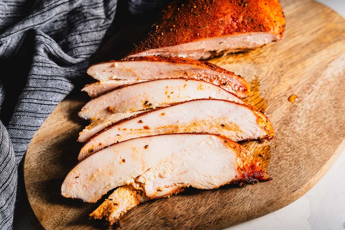 sliced smoked chicken breast on cutting board