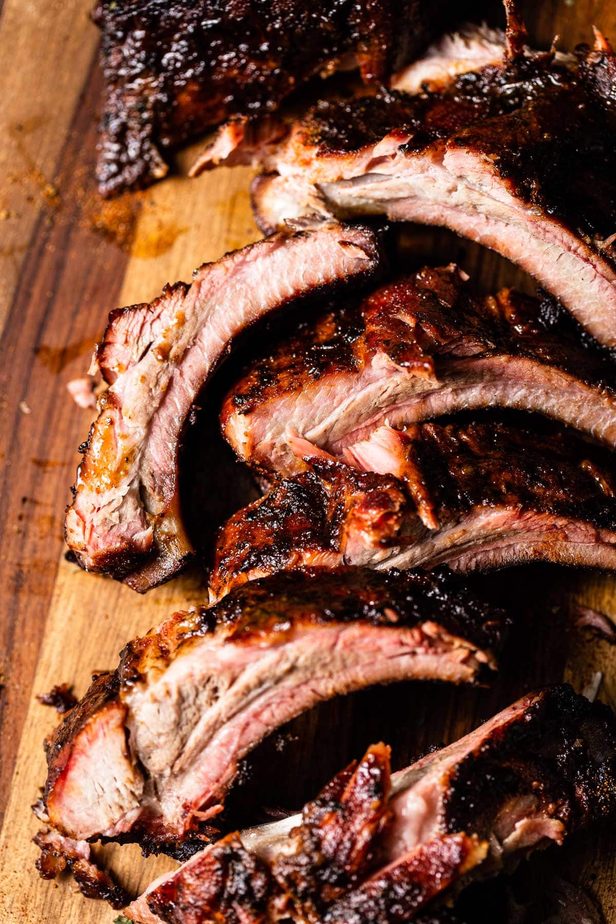 smoked baby back ribs on cutting board close up