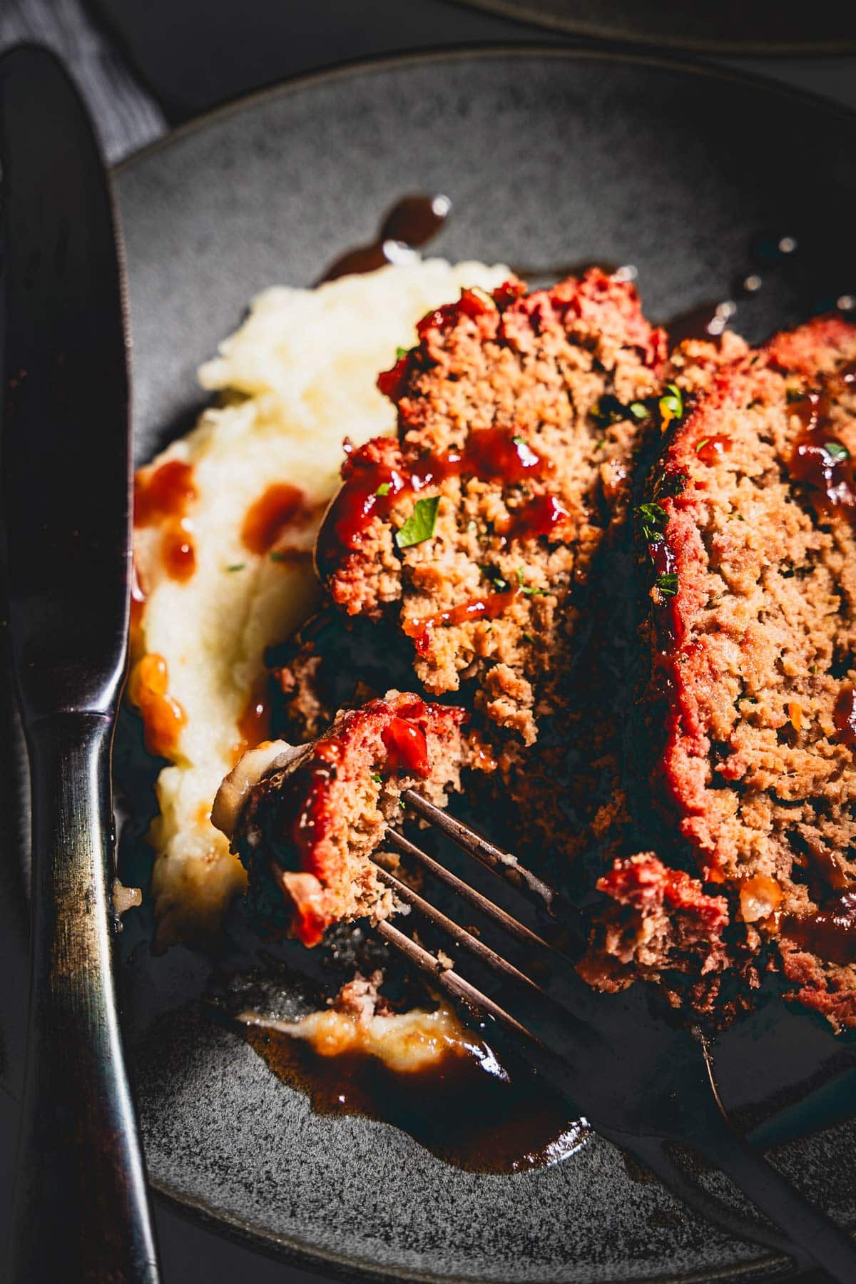 smoked meatloaf with mashed potatoes and sauce on a plate