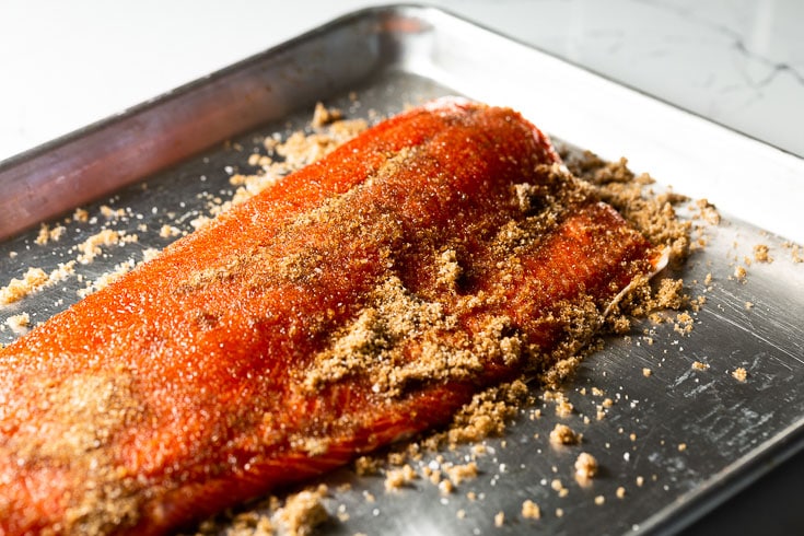 smoked salmon brining with kosher salt and sugar on a sheet pan