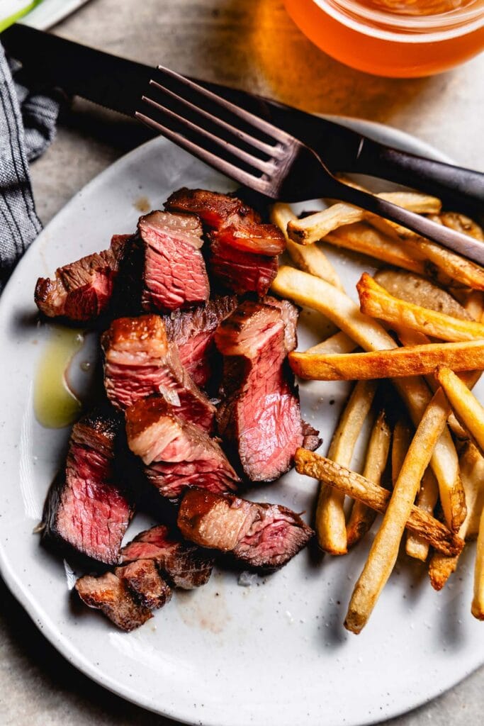 sous vide picanha steak sliced on plate with fries