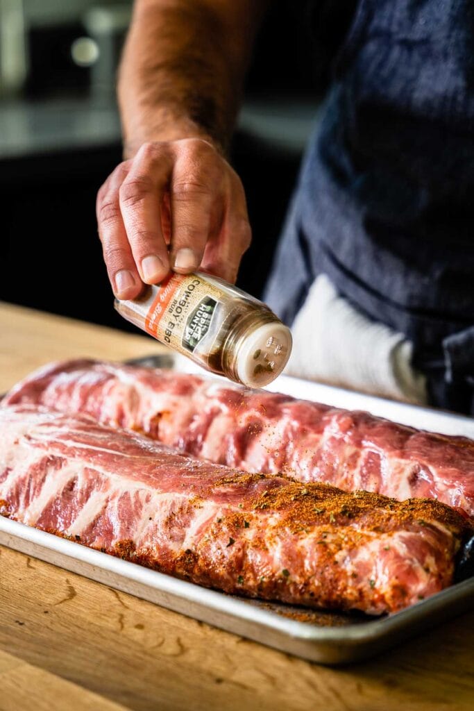 sprinkling spice king cowboy bbq on ribs